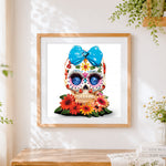 Finished 3D jewelled sugar skull with blue bow cross stitch artwork displayed