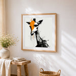 Abstract giraffe with orange splash cross stitch artwork displayed on wall as home decor