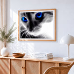 Abstract glowing blue eyes cat cross stitch artwork displayed on wall as home decor