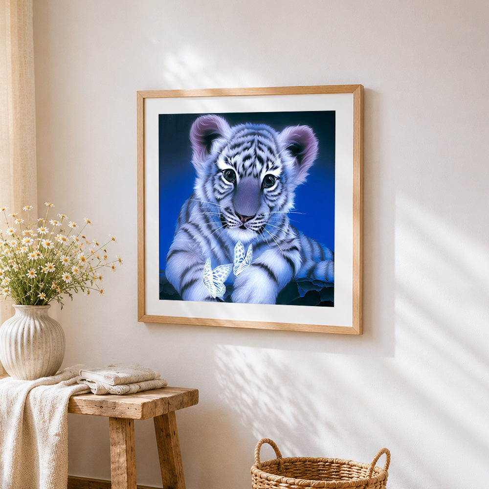 Adorable white tiger cub with butterflies cross stitch artwork displayed on wall as home decor