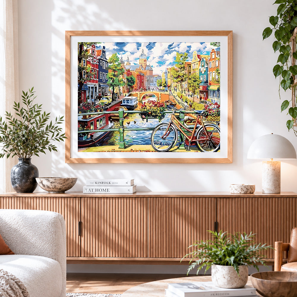Finished amsterdam canal and bicycle cross stitch artwork displayed