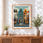 Finished amsterdam canal houses and bicycle cross stitch artwork displayed