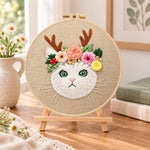 Antler flower kitten embroidery kit finished hoop displayed on a wooden stand as cozy tabletop decor