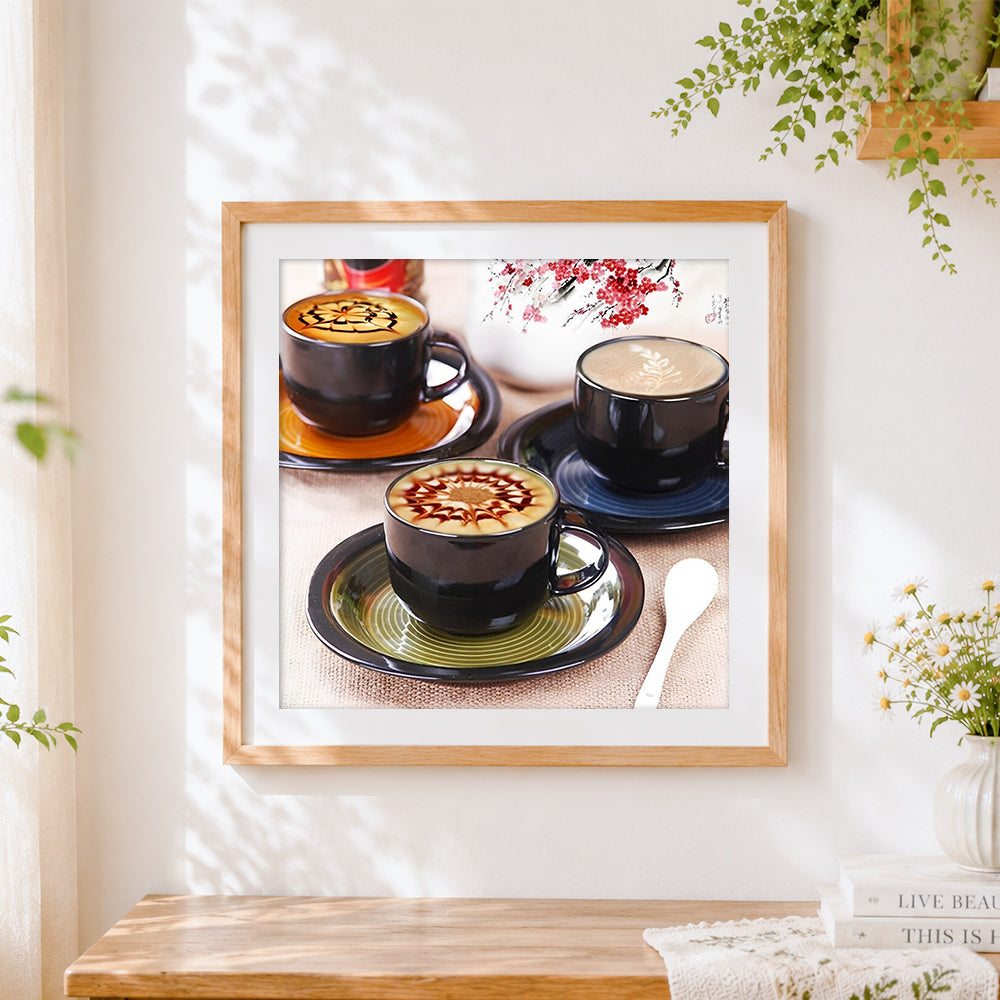 Finished artistic latte art in black cups cross stitch artwork displayed