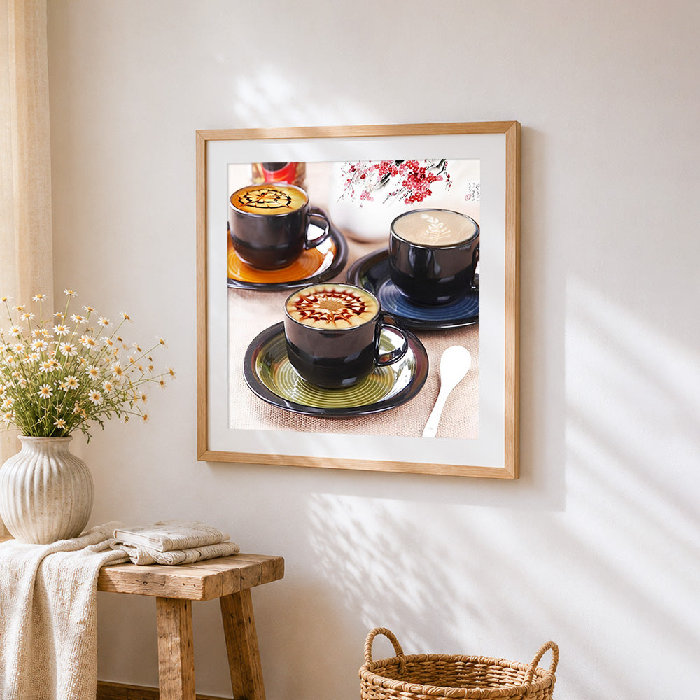Artistic latte art in black cups cross stitch artwork displayed on wall as home decor