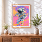 Finished astronaut in orange splatter cross stitch artwork displayed