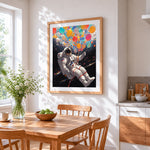 Astronaut with colourful balloons cross stitch artwork displayed on wall as home decor