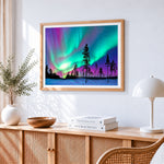 Aurora borealis over snowy forest cross stitch artwork displayed on wall as home decor