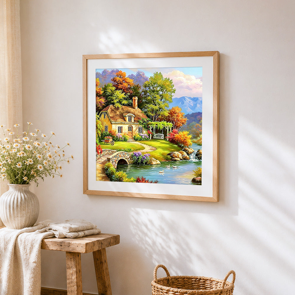 Autumn lake cottage with swans cross stitch artwork displayed on wall as home decor