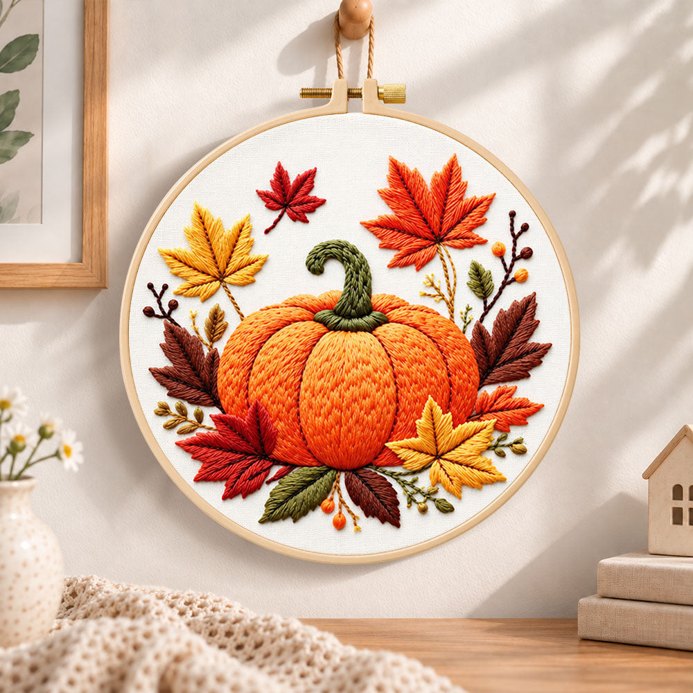 Autumn pumpkin and maple leaves embroidery hoop wall art displayed as warm and cosy handmade home decor