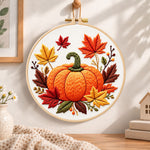 Autumn pumpkin and maple leaves embroidery hoop wall art displayed as warm and cosy handmade home decor