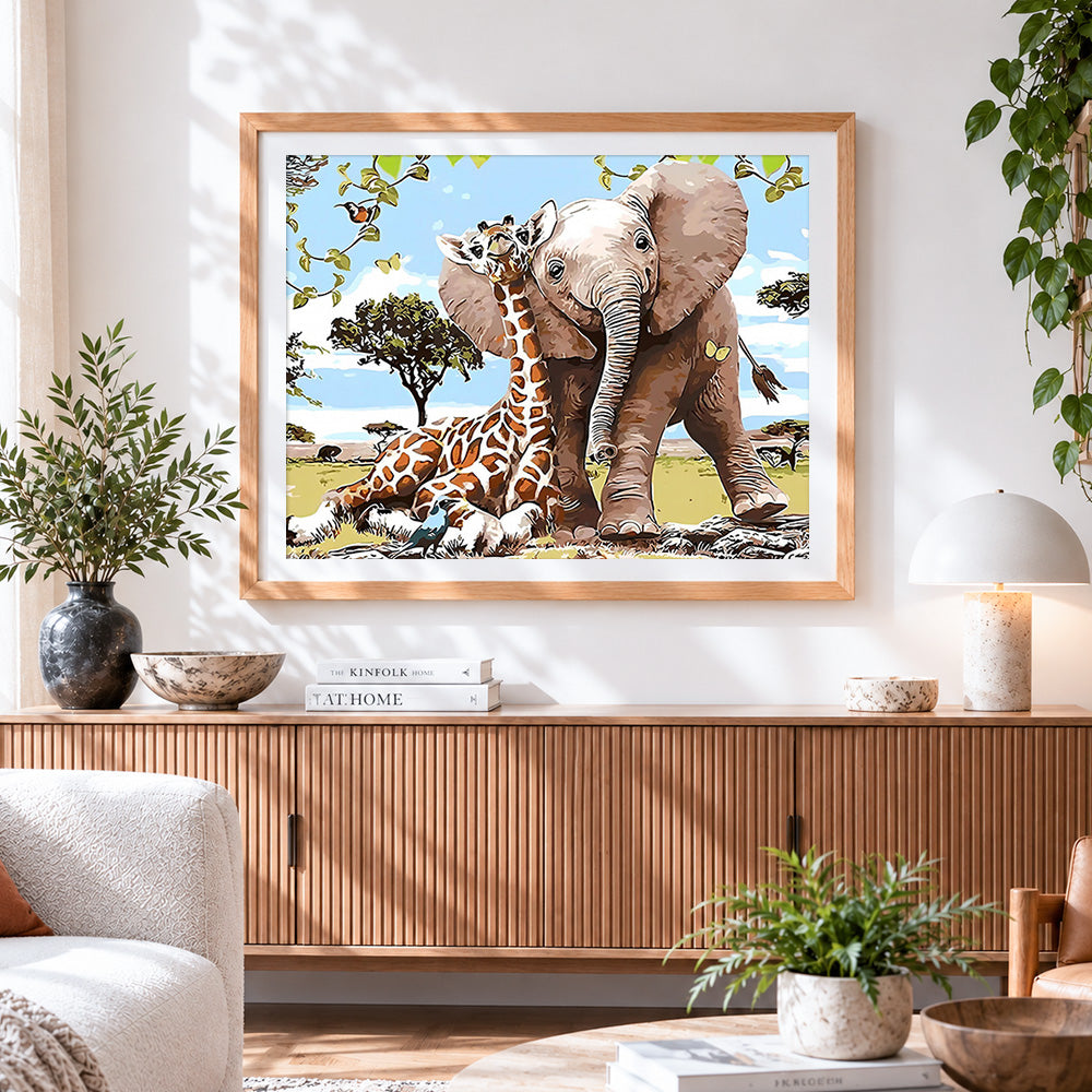 Finished baby elephant and giraffe cross stitch artwork displayed