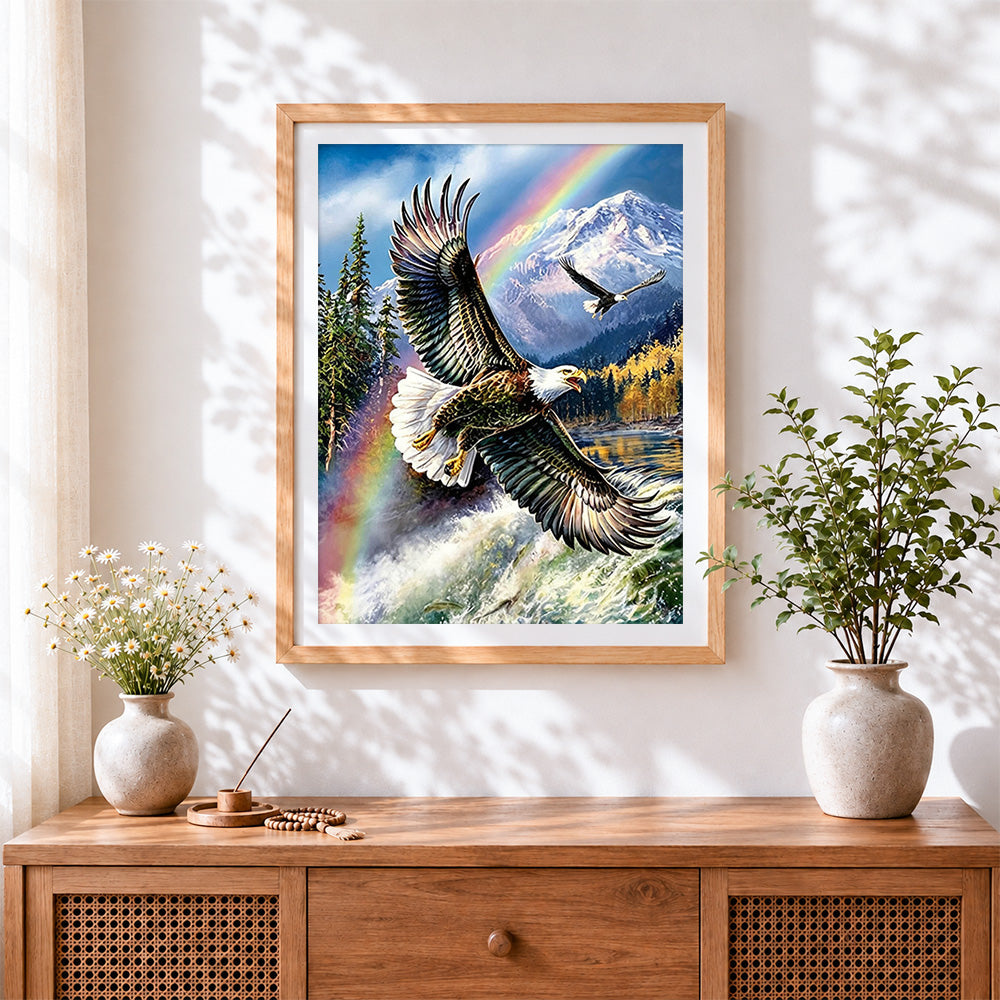 Finished bald eagle flying over mountains and rainbow cross stitch artwork displayed