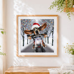 Finished basset hound riding a motorbike with santa hat cross stitch artwork displayed