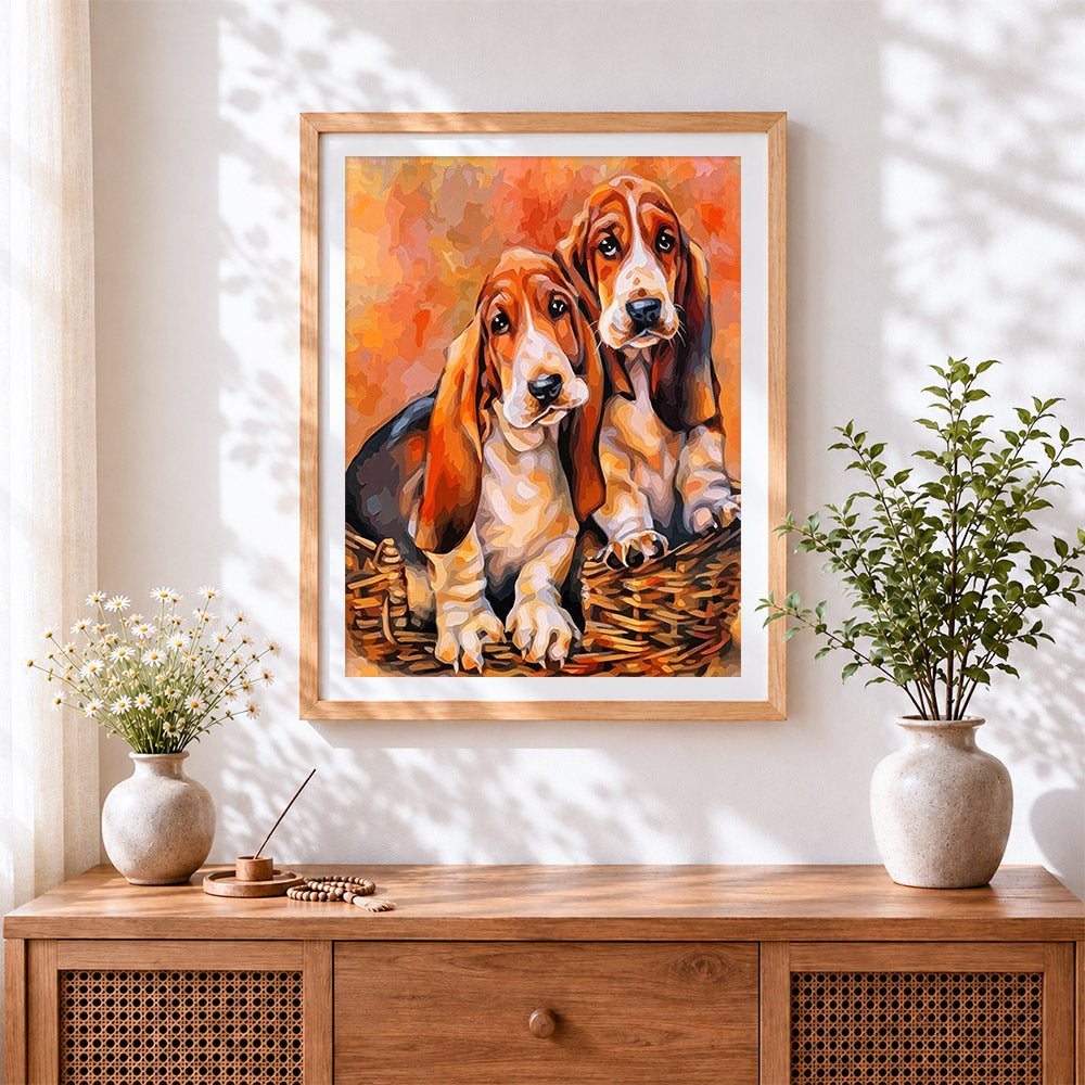 Finished basset hounds in a basket cross stitch artwork displayed