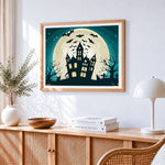Bats flying over haunted house and full moon cross stitch artwork displayed on wall as home decor