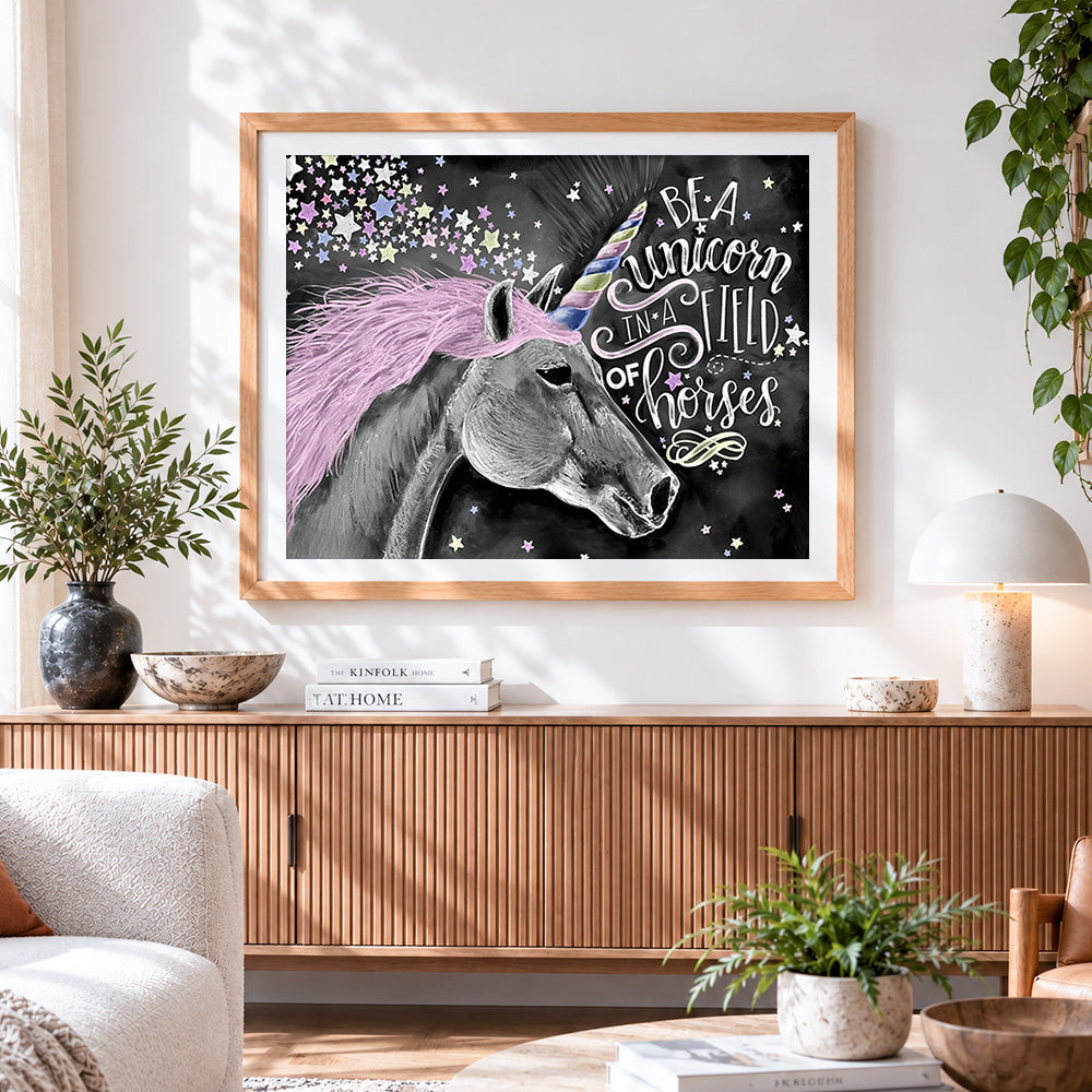 Finished be a unicorn in a field of horses cross stitch artwork displayed