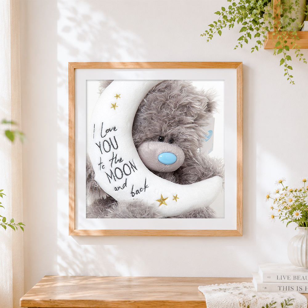 Finished bear and crescent moon cross stitch artwork displayed