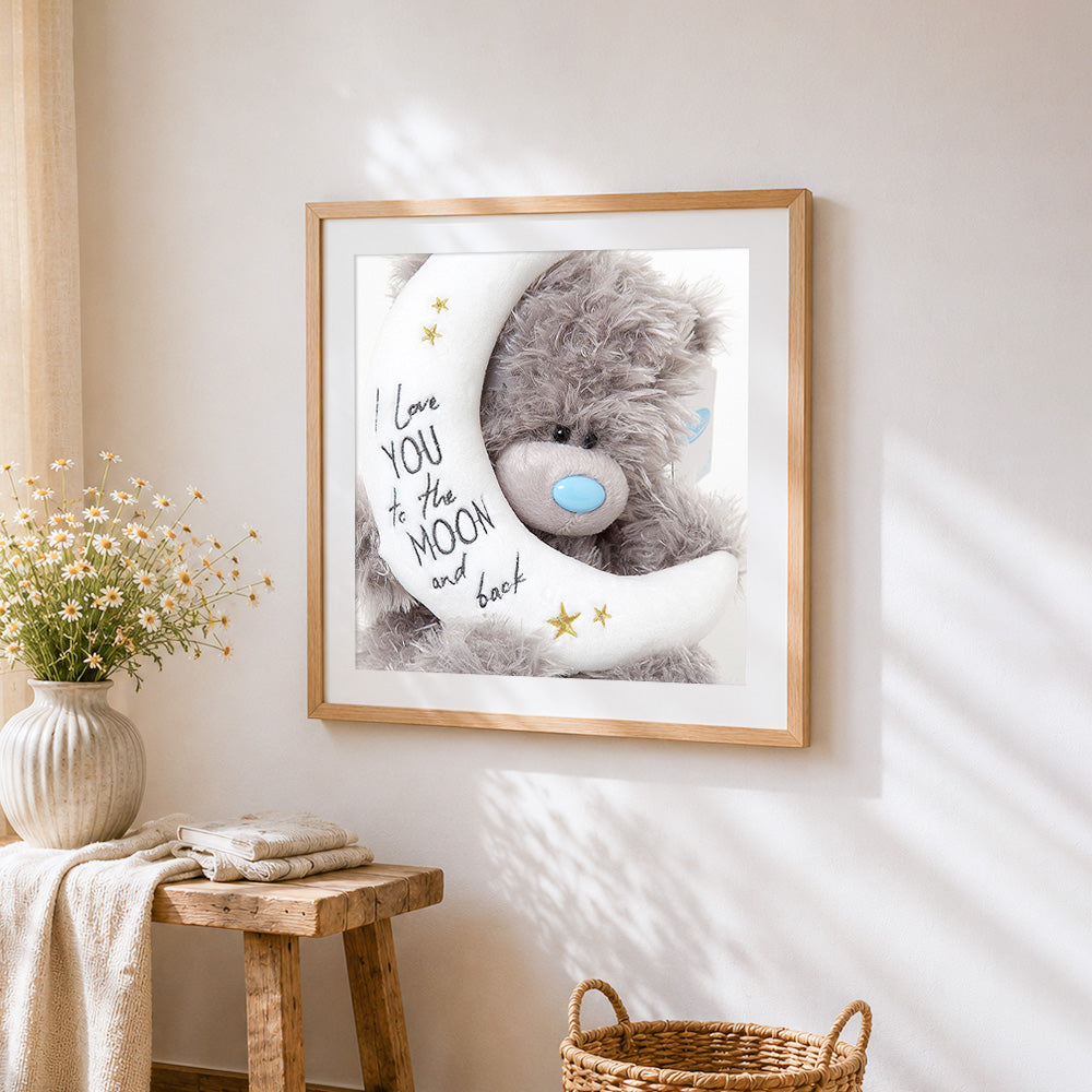 Bear and crescent moon cross stitch artwork displayed on wall as home decor