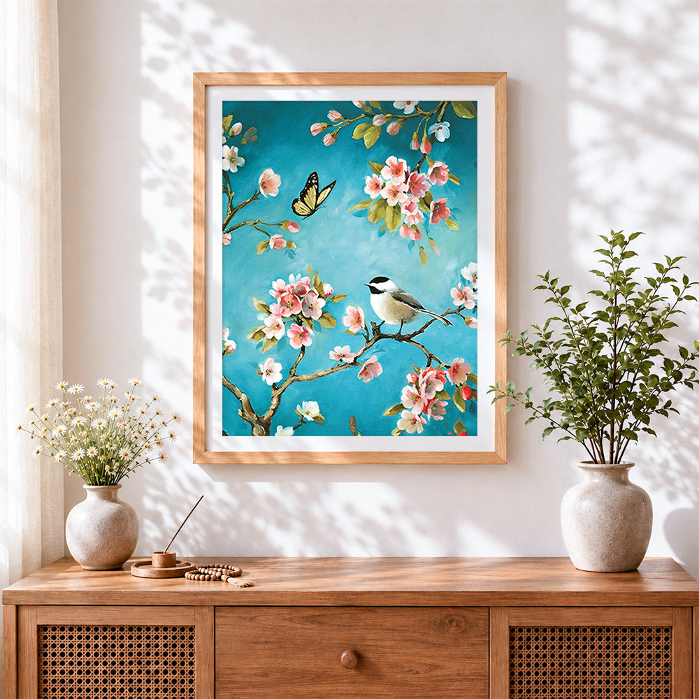 Finished bird and butterfly on blossom branch cross stitch artwork displayed