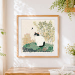 Finished black and white cat in spring cross stitch artwork displayed