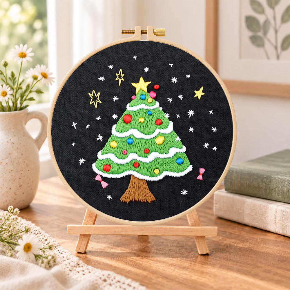 Black background tree embroidery kit finished hoop displayed on a wooden stand as cosy tabletop decor
