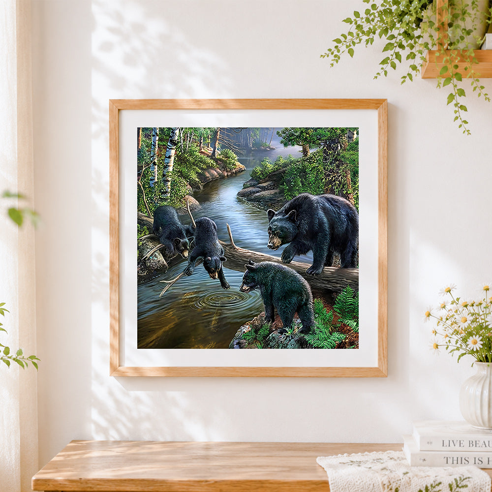 Finished black bear family by forest stream cross stitch artwork displayed
