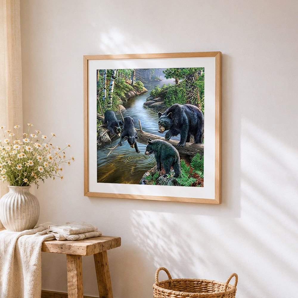 Black bear family by forest stream cross stitch artwork displayed on wall as home decor