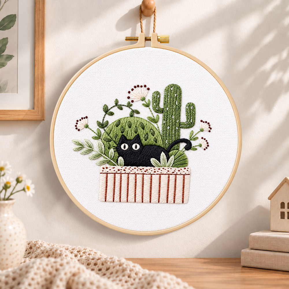Black cat and cactus embroidery hoop wall art displayed as warm and cosy handmade home decor