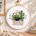 Black cat and cactus embroidery hoop wall art displayed as warm and cosy handmade home decor