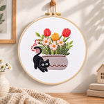 Black cat and tulips embroidery hoop wall art displayed as warm and cosy handmade home decor