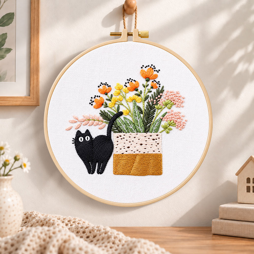 Black cat and wildflowers embroidery hoop wall art displayed as warm and cosy handmade home decor