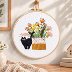 Black cat and wildflowers embroidery hoop wall art displayed as warm and cosy handmade home decor