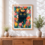 Finished black cat in wildflower garden cross stitch artwork displayed