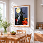 Black cat in witch hat with full moon cross stitch artwork displayed on wall as home decor