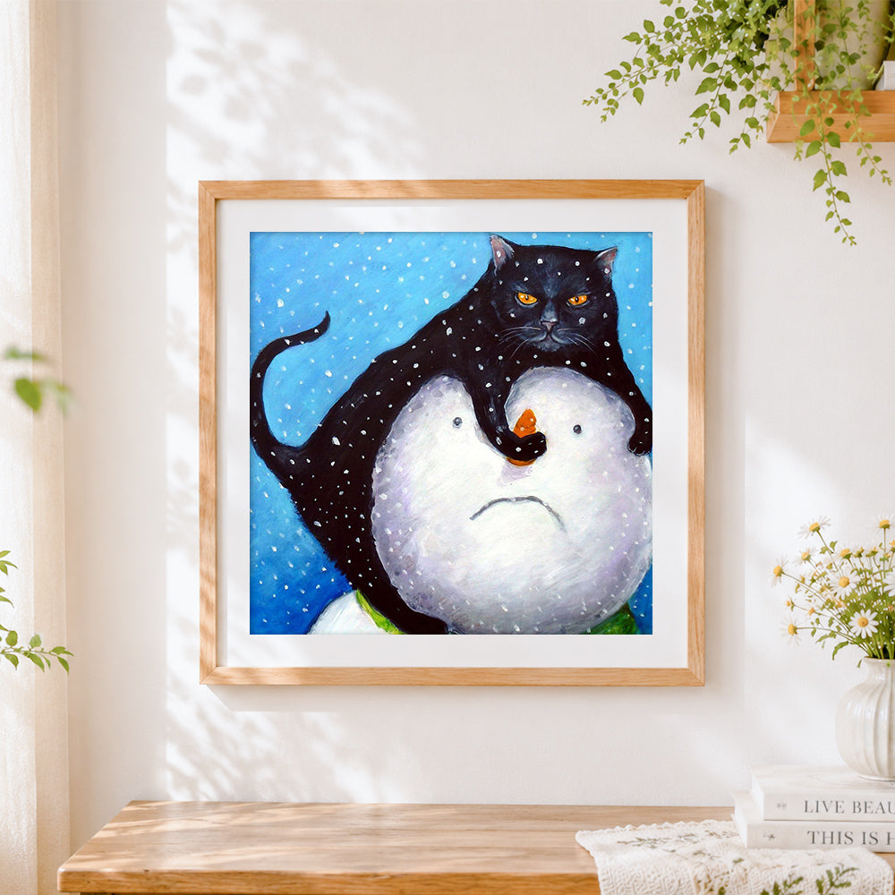 Finished black cat on snowman cross stitch artwork displayed