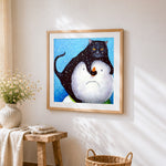 Black cat on snowman cross stitch artwork displayed on wall as home decor