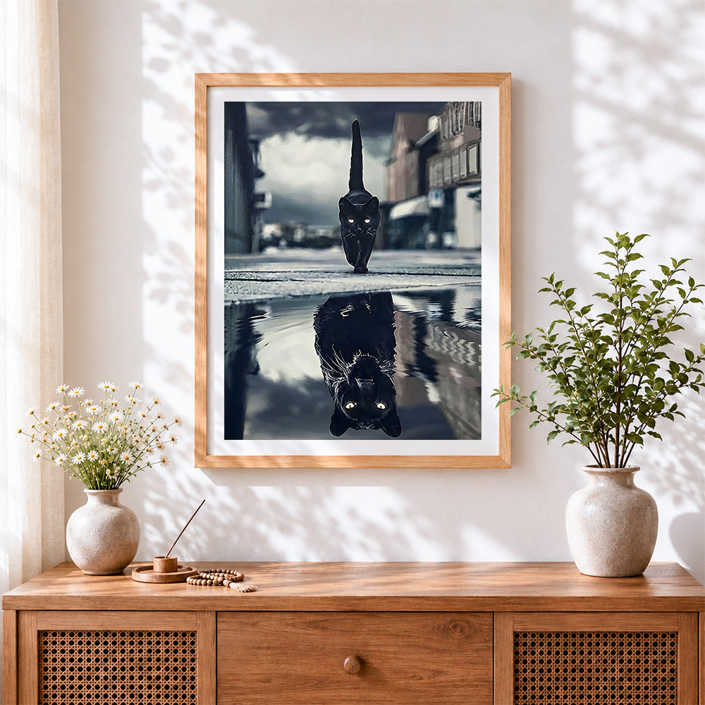 Finished black cat reflection cross stitch artwork displayed