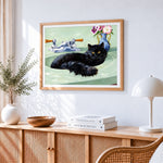 Black cat sitting in a green sink cross stitch artwork displayed on wall as home decor