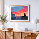 Black cat watching the sunset on a roof cross stitch artwork displayed on wall as home decor