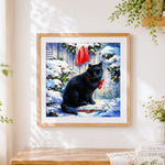 Finished black cat with red bow in the snow cross stitch artwork displayed