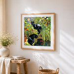 Black cats in garden with koi fish cross stitch artwork displayed on wall as home decor