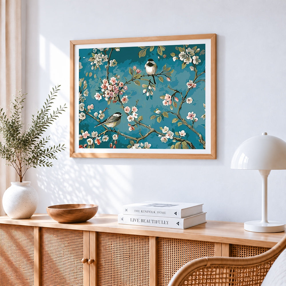 Blossoming cherry tree with birds cross stitch artwork displayed on wall as home decor