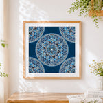 Finished blue and white patterned mandala cross stitch artwork displayed