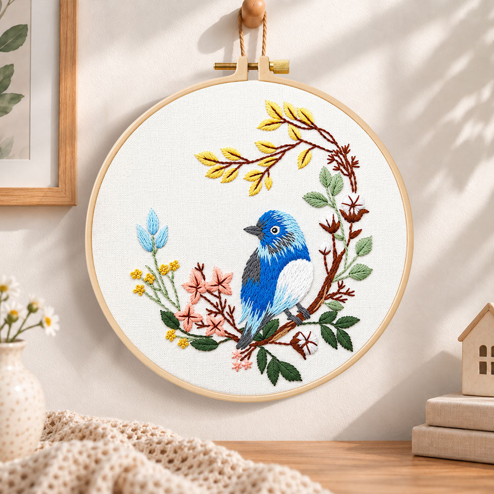 Blue bird on floral branch embroidery hoop wall art displayed as warm and cosy handmade home decor