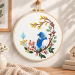 Blue bird on floral branch embroidery hoop wall art displayed as warm and cosy handmade home decor