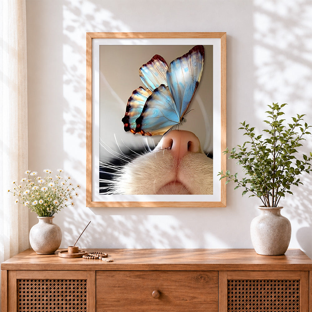 Finished blue butterfly on cat nose cross stitch artwork displayed