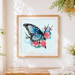 Finished blue butterfly with cherry blossoms cross stitch artwork displayed