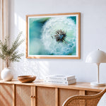 Blue dandelion cross stitch artwork displayed on wall as home decor