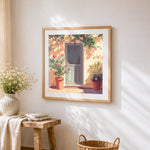 Blue door and pink oleander cross stitch artwork displayed on wall as home decor